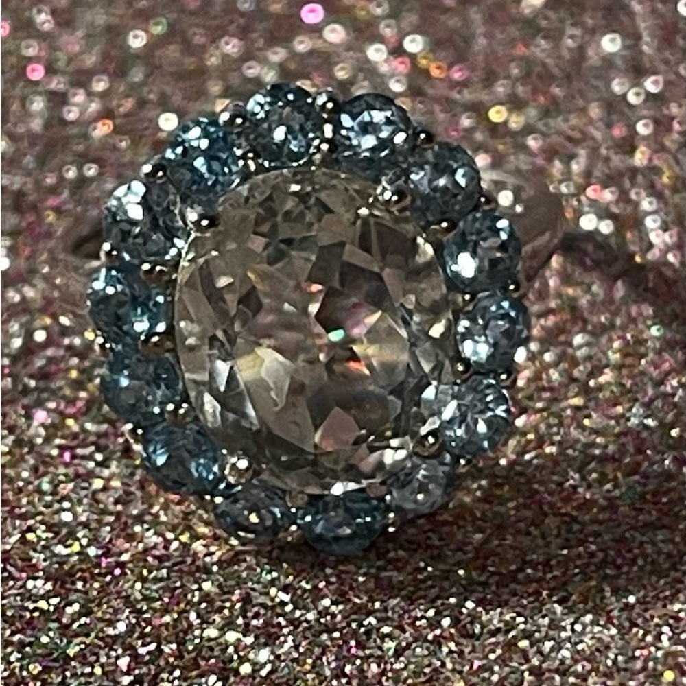 Sterling silver ring with clear stone surrounded by light blue stones.